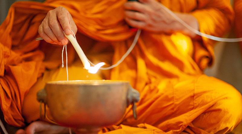 Moine bouddhiste lors d’un rituel avec une bougie